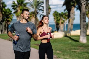 A man and woman running together outside