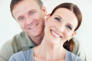 Woman smiling with her husband after a successful neck lift, showcasing a rejuvenated and youthful appearance