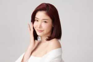 Beautiful young asian woman with clean fresh skin on grey background