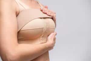 Woman wearing a post-surgical compression bra and implant stabilizer after medical mammoplasty, mastopexy, or breast enlargement surgery.