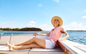 Woman on boat wearing shorts confidently after having a thigh lift