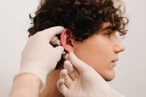 Surgeon examining a patient's ears before ear pinning surgery.