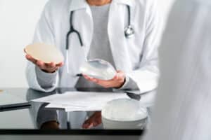 Plastic surgeon comparing two breast implant sizes.